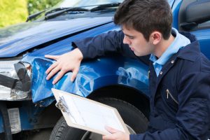 Auto,Workshop,Mechanic,Inspecting,Damage,To,Car,And,Filling,In